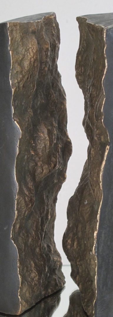 Zwei Bronze-Formen mit glatter Außenfläche und innen gegenüberliegenden Bruchflächen