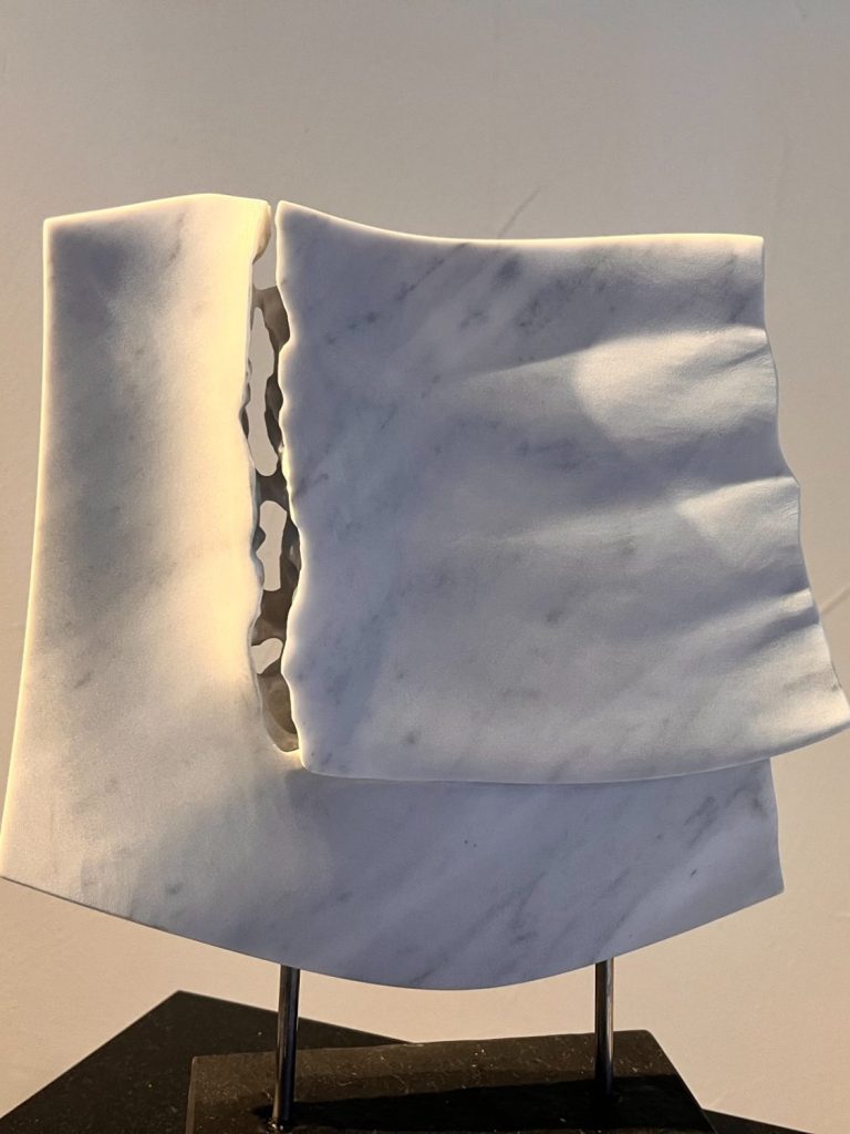 Tuchfühlung Eine Skulptur aus weißem Marmor, die wie ein durchbrochenes Tuch wirkt